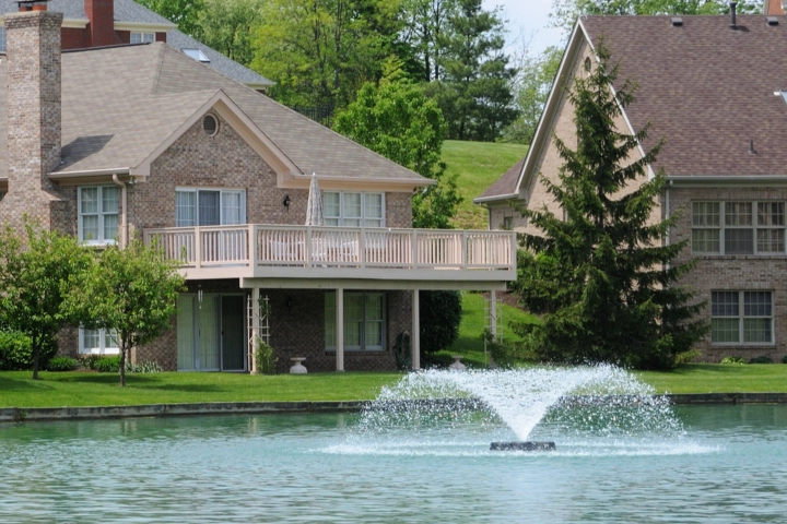 Large fountain in a communal lake and homes - aquatic management services by Sorko Services in Central Florida