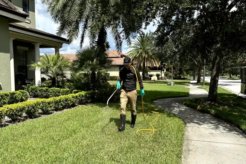 A Sorko Services Pest Technician Sprays a Florida Lawn to Treat Unwanted Pests